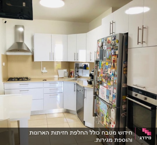 מטבח מודרני עם ארונות לבנים ומקרר עם מגנטים